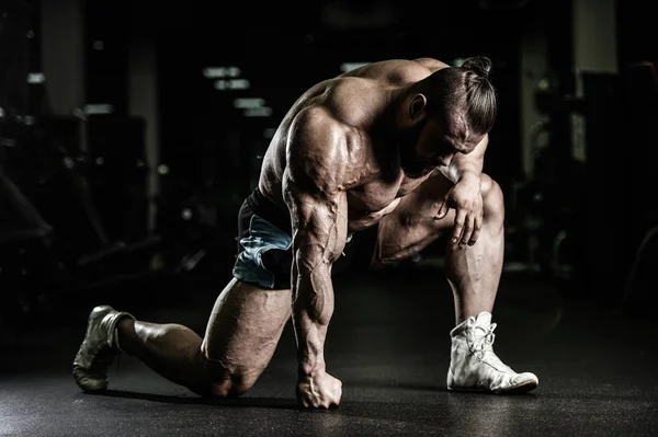 Schöner fitter kaukasischer muskulöser Mann, der seine Muskeln im Fitnessstudio spielen lässt — Stockfoto