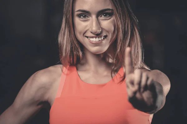 Portret van mooie sexy meisje achtergrond sportschool stopbord hand — Stockfoto