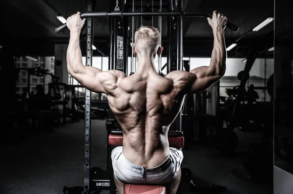 Schöner kraftvoller athletischer Mann Diättraining, das Rückenmuskeln aufpumpt — Stockfoto