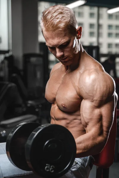 Gutaussehender Kraftsportler beim Diättraining, das Muskeln aufpumpt — Stockfoto