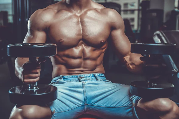 Caucasian sexy fitness male model execute exercise with dumbbell