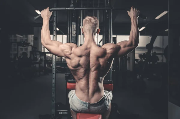 Schöner kraftvoller athletischer Mann Diättraining, das Rückenmuskeln aufpumpt — Stockfoto