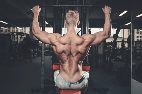 Schöner kraftvoller athletischer Mann Diättraining, das Rückenmuskeln aufpumpt — Stockfoto