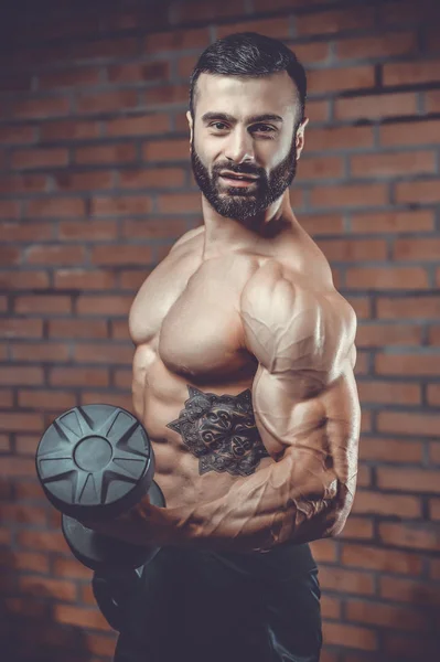 Handsome power athletic man on diet training pumping up muscles