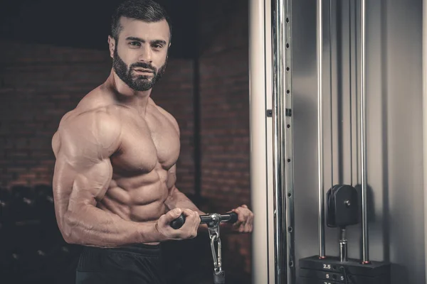 Handsome power athletic man on diet training pumping up muscles