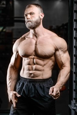 Yakışıklı uygun beyaz kas adam kasları spor salonunda esneme