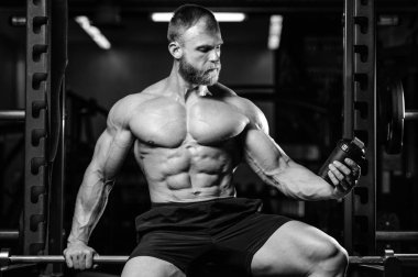 Yakışıklı uygun beyaz kas adam kasları spor salonunda esneme