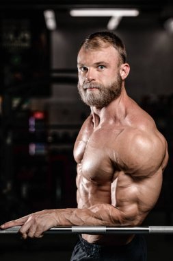 Yakışıklı uygun beyaz kas adam kasları spor salonunda esneme