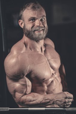 Yakışıklı uygun beyaz kas adam kasları spor salonunda esneme