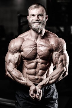 Yakışıklı uygun beyaz kas adam kasları spor salonunda esneme