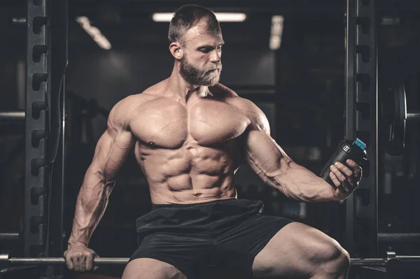 Bonito ajuste caucasiano muscular homem flexionando seus músculos no ginásio — Fotografia de Stock