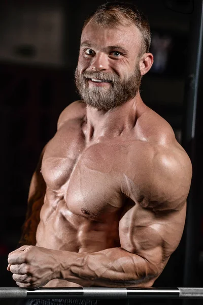 Pohledný přizpůsobit kavkazské svalnatý muž protahuje svaly v tělocvičně — Stock fotografie