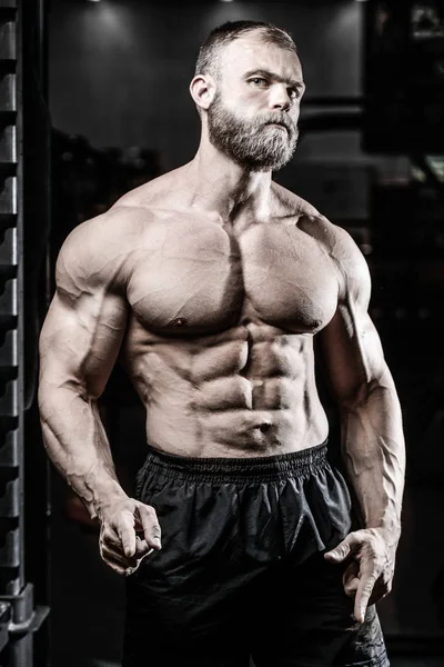 Bel ajustement caucasien musclé homme fléchissant ses muscles dans la salle de gym — Photo