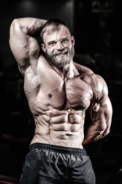 Handsome fit caucasian muscular man flexing his muscles in gym — Stock Photo, Image
