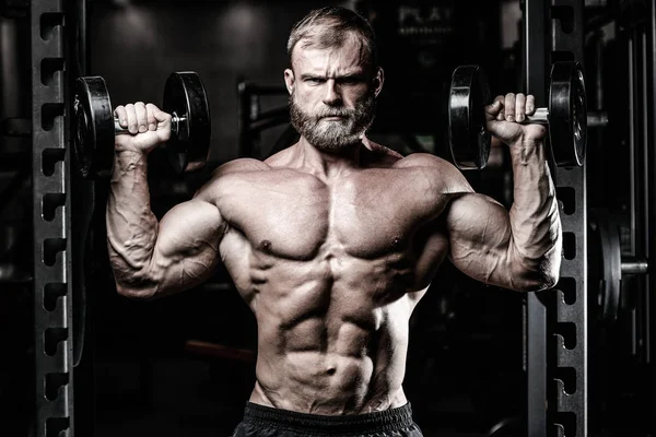 Bonito ajuste caucasiano muscular homem flexionando seus músculos no ginásio — Fotografia de Stock