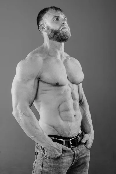 Brutale gespierde man in studio op grijze achtergrond fitness model — Stockfoto