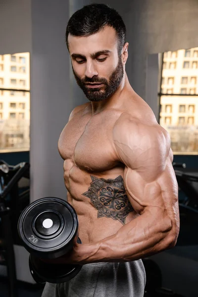Handsome power athletic man on diet training pumping up muscles
