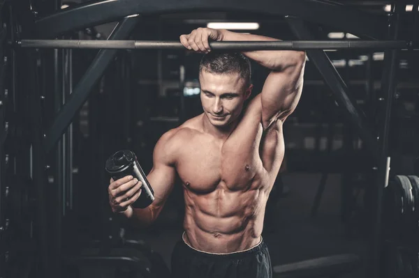 Muskulöser Mann ruht sich nach dem Sport aus und trinkt aus Shaker — Stockfoto