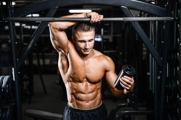 Muskulöser Mann ruht sich nach dem Sport aus und trinkt aus Shaker — Stockfoto