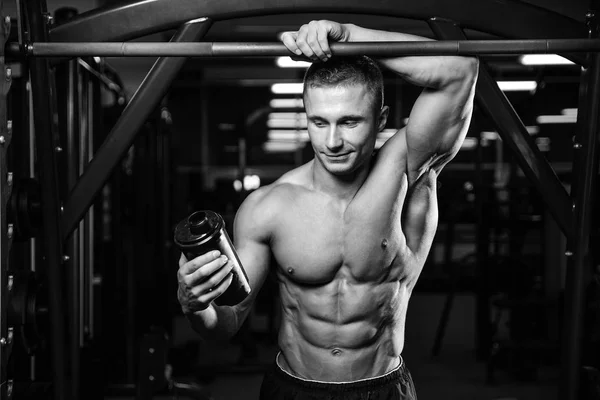 Muskulöser Mann ruht sich nach dem Sport aus und trinkt aus Shaker — Stockfoto