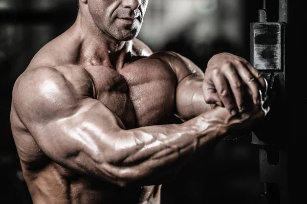 Schöner fitter kaukasischer muskulöser Mann, der seine Muskeln im Fitnessstudio spielen lässt — Stockfoto