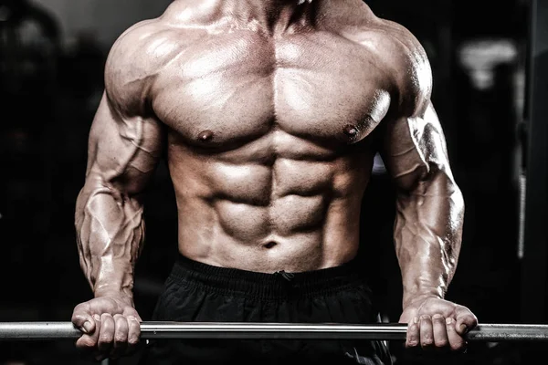 Gutaussehender Kraftsportler beim Diättraining, das Muskeln aufpumpt — Stockfoto