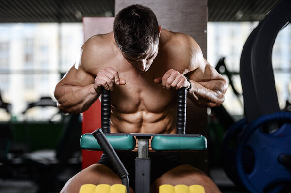 Muscular handsome athletic bodybuilder fitness model posing afte