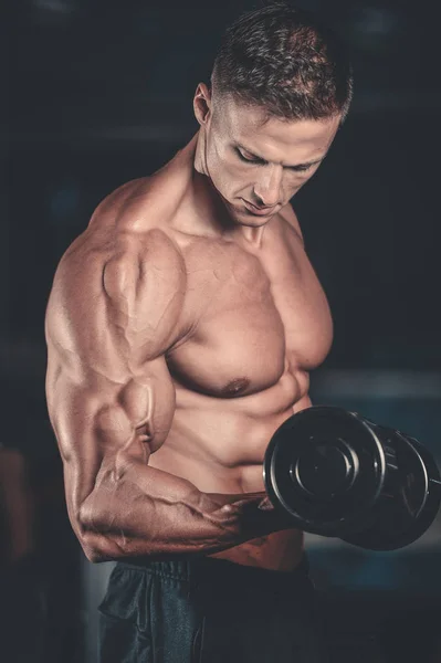 Gutaussehender Kraftsportler beim Diättraining, das Muskeln aufpumpt — Stockfoto