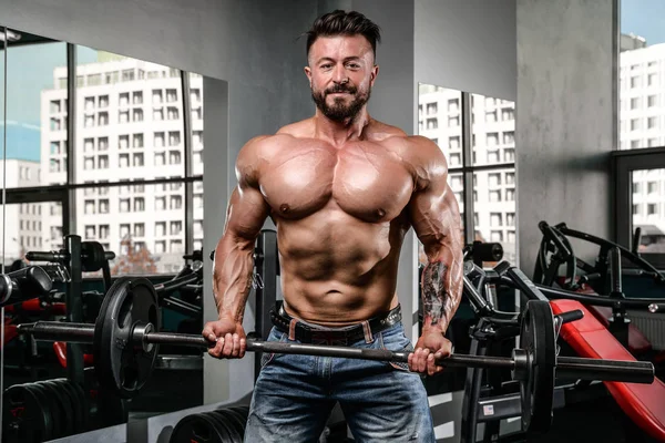 Handsome power athletic man on diet training pumping up muscles