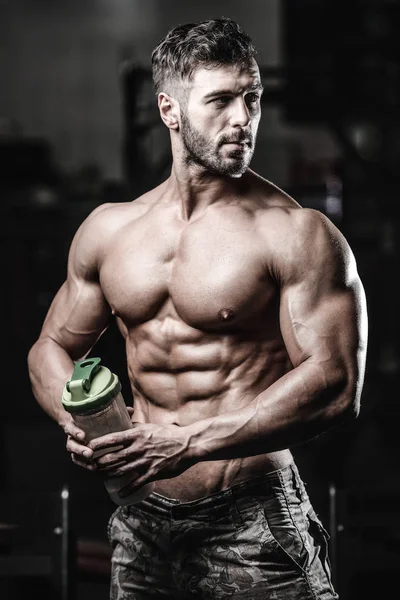 Uomo muscolare che riposa dopo l'esercizio e beve dallo shaker — Foto Stock