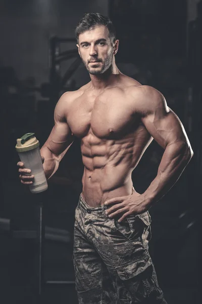 Hombre muscular Descansando después del ejercicio y bebiendo de Shaker —  Fotos de Stock