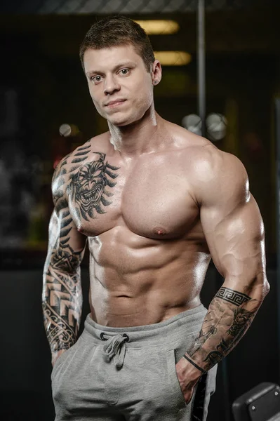 Güçlü ve yakışıklı atletik genç kaslı adam dövme 