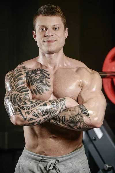 Forte e bello atletico giovane tatuaggio uomo con muscoli — Foto Stock