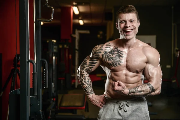 Fuerte y guapo atlético joven tatuaje hombre con músculos —  Fotos de Stock