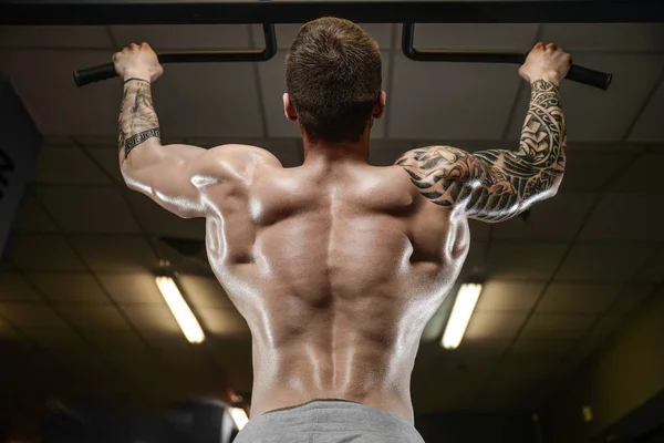 Homem de tatuagem jovem atlético forte e bonito com músculos — Fotografia de Stock