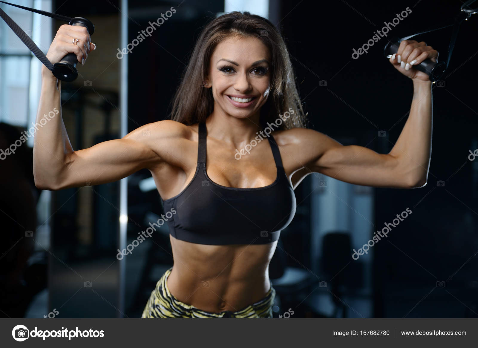 Sexy athletic young girl training arms in gym Stock Photo antondotsenko 167682780