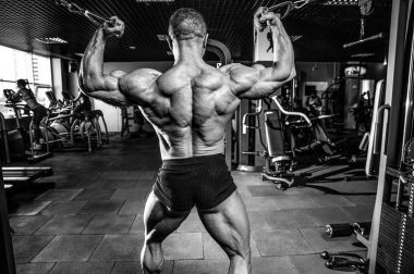 Yakışıklı model genç adam eğitim kollarında spor salonu