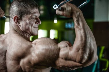 Yakışıklı model genç adam eğitim kollarında spor salonu