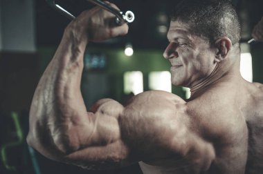 Yakışıklı model genç adam eğitim kollarında spor salonu