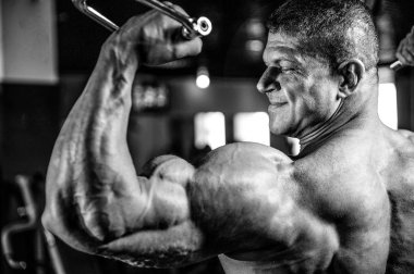 Yakışıklı model genç adam eğitim kollarında spor salonu