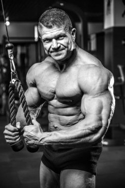 Yakışıklı model genç adam eğitim kollarında spor salonu