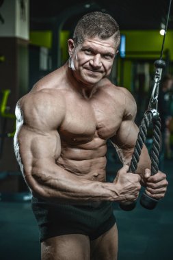 Yakışıklı model genç adam eğitim kollarında spor salonu