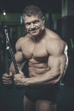 Yakışıklı model genç adam eğitim kollarında spor salonu