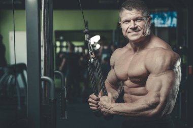 Yakışıklı model genç adam eğitim kollarında spor salonu