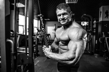 Yakışıklı model genç adam eğitim kollarında spor salonu