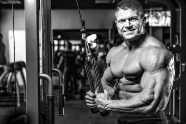 Yakışıklı model genç adam eğitim kollarında spor salonu