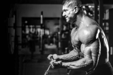 Yakışıklı model genç adam eğitim kollarında spor salonu