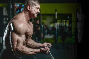 Yakışıklı model genç adam eğitim kollarında spor salonu