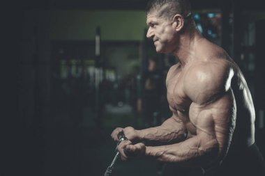 Yakışıklı model genç adam eğitim kollarında spor salonu