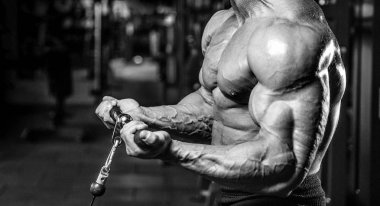 Yakışıklı model genç adam eğitim kollarında spor salonu